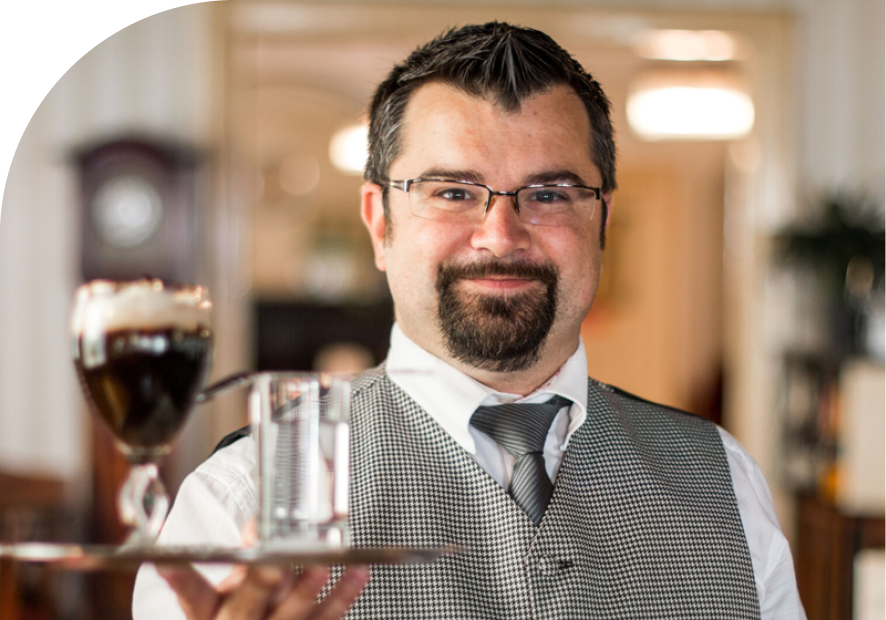 Kellner Klaus-Dieter mit Tablett in der Hand